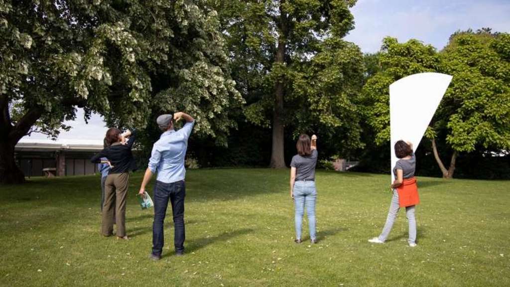 Besuchende im Beower Park interagieren mit Skulptur.