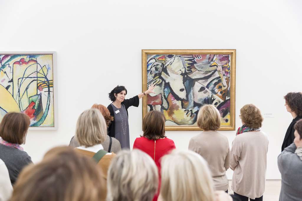 Participants take part in a tour about a painting exhibition.