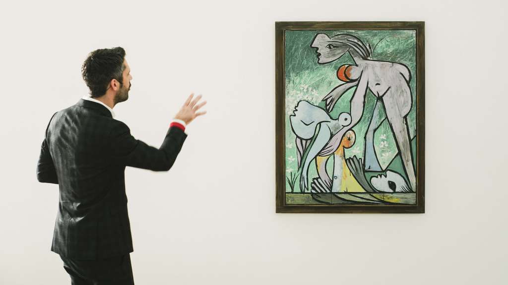 Le curateur R. Bouvier présente un tableau dans une salle du musée