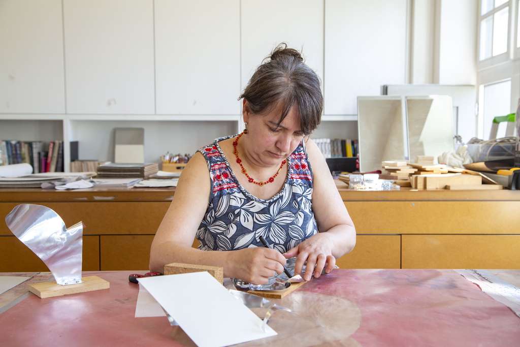 A woman concentrates on her art project in an art studio.