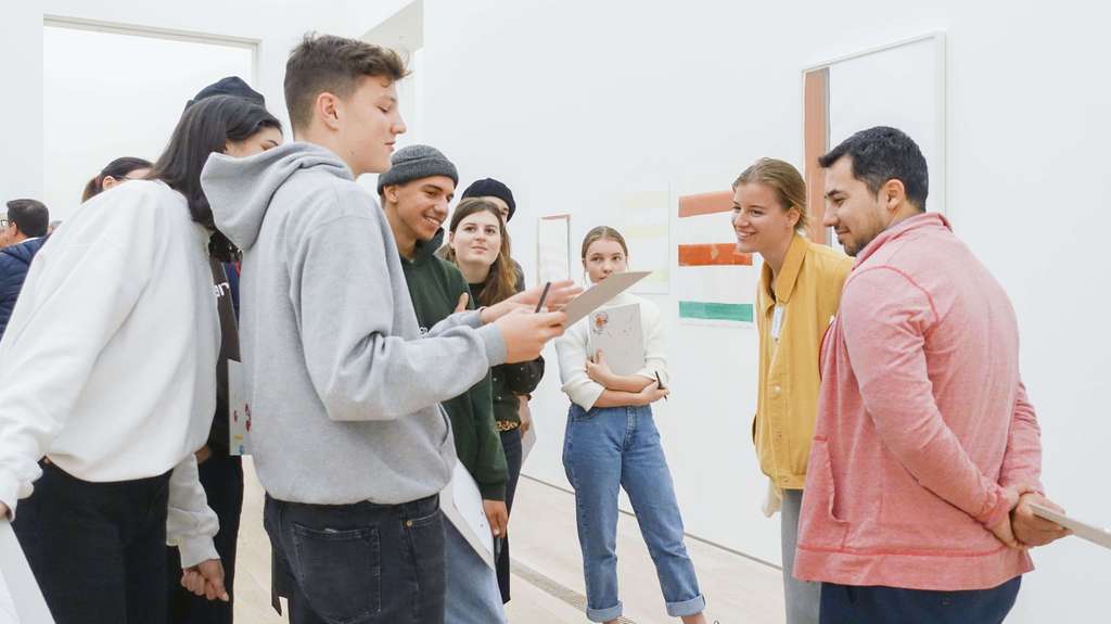 Junge Menschen diskutieren zusammen im Museum.