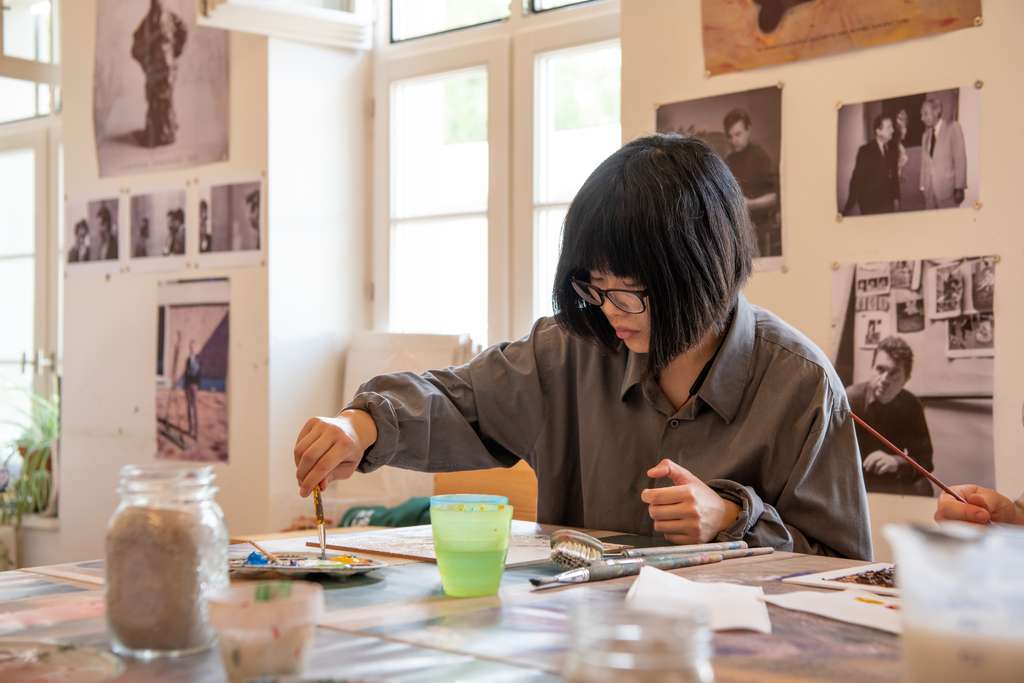 Woman works on an art project in museum studio.