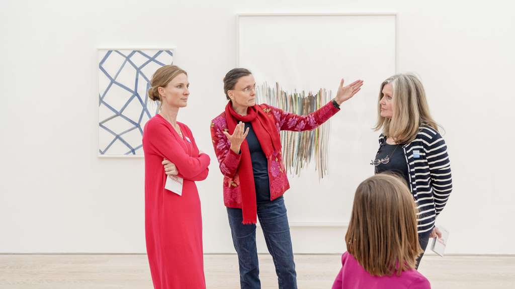 Group of women talk with each other in a museum hall