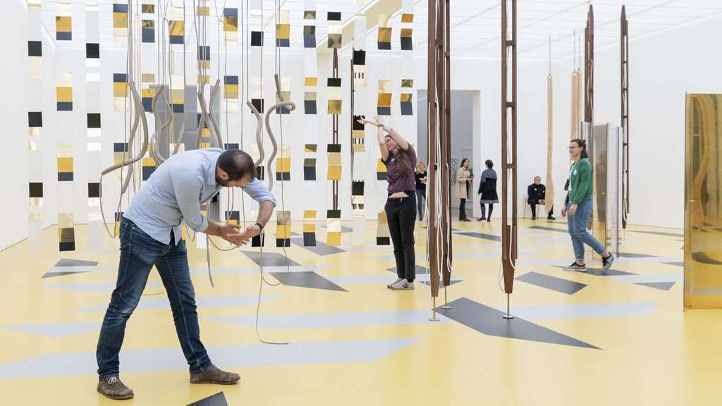 Menschen agieren mit der Kunst in einem Ausstellungssaal.
