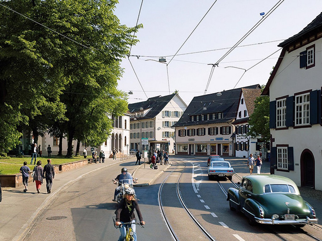 Street in Riehen town with tram tracks, cars and bicycles